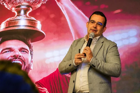 Márcio Borba conduzindo palestra com microfone em evento corporativo